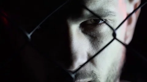 The appearance of the boxer's man behind the net. Close-up, dark room, red light Stock Footage 80862240