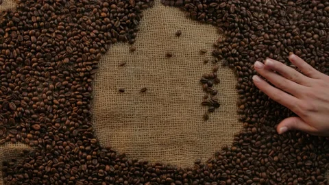 Appearance of coffee cup icon made of beans by slow motion waving woman's hand Stock Footage 135657756