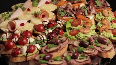 An appetizer board with various bruschetta for a buffet: jamon, ham, pate, .. Stock Footage 303300605
