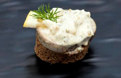 Appetizer canape from rye bread with herring slice and beetroot 写真素材