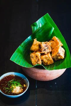 An appetizer of deep fried tofu cubes served in banana leaf with a dipping sa Stock Photos