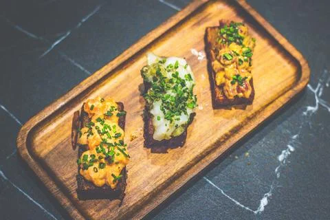An appetizer of pan fried potato rectangles with a bed Avocado mousse and ... Stock Photos