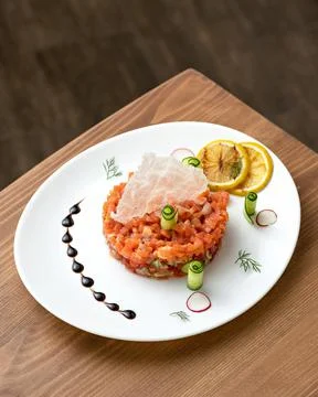 Appetizer of red sturgeon fish and vegetables. Platter with salmon pieces, lemon Stock Photos