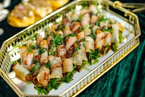 Appetizer snacks with bacon wrapped scallops and fresh herbs Stock Photos