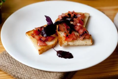 Appetizer with tomatoes and basil on toasted bread Stock Photos