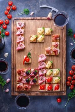Appetizers cutting board with assorted snacks and wine Stock Photos