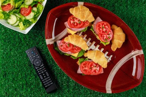 Appetizers on the plate with tv remote controller for the football party. Stock Photos