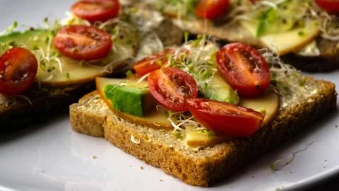 Appetizing and nutritious sandwich with avocado, cheese and tomatoes Stock Photos