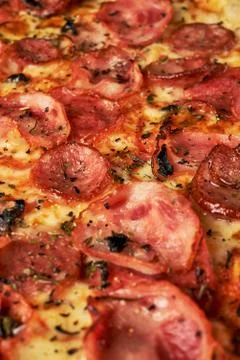 Appetizing background pepperoni pizza with bacon closeup of filling the frame Foto stock