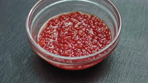 Appetizing background of red caviar. Salmon or trout caviar is laid out in a pla Stock Footage 141376604
