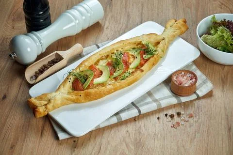 Appetizing baked open pie with salted suluguni cheese, salmon and avocado on  Stock Photos