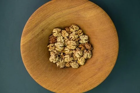 Appetizing beautiful whole walnut kernels in a deep wooden plate on a harmoni Stock Photos