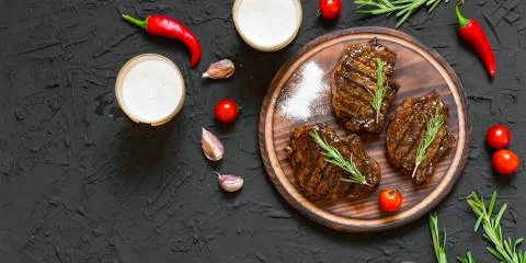 Appetizing beef steaks, beer and rosemary Photos
