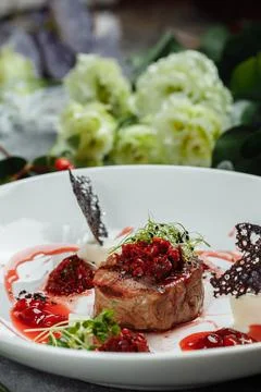 Appetizing beef in sweet sauce close up. Chopped beef meat in cherry sauce with Stock Photos