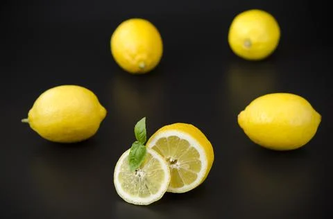 Appetizing bright lemons on a black background Stock Photos