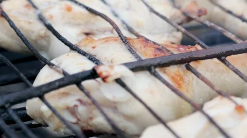 Appetizing brown crusted chicken shanks are fried with onions on a rusty grill Video stock 116420526