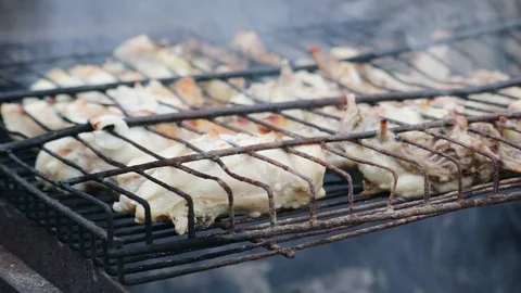 Appetizing brown crusted chicken shanks are fried with onions on a rusty grill 스톡 동영상 116500739