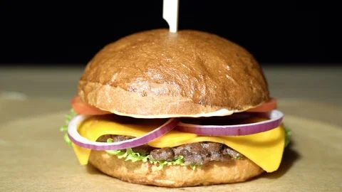 Appetizing burger with beef cutlet, lettuce, tomato, onion and cheese Stock Footage 113604120