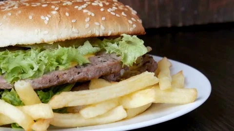 Appetizing burger sandwich is rotating on the black background with copy space. Video stock 336579476