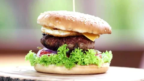 Appetizing burger sandwich is rotating on the white background with copy space. Video stock 336579308