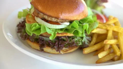Appetizing burger sandwich is rotating on the white background with copy space. Video stock 336579505