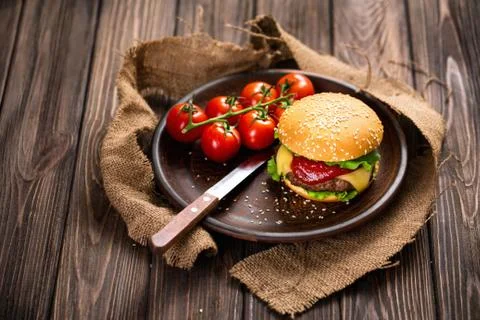 Appetizing burger with tomatoes on table Foto stock