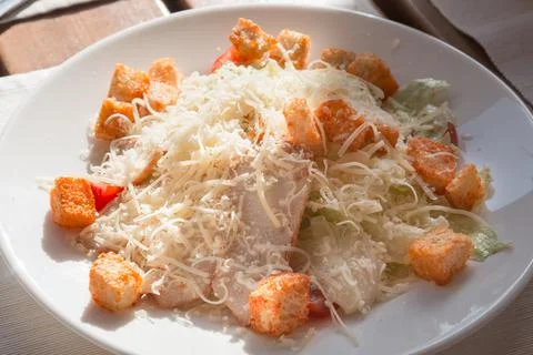Appetizing caesar salad with bacon, croutons and cheese on a white plate in a Stock Photos