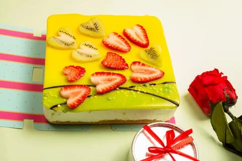 Appetizing cake covered with icing, decorated with hearts of strawberries and Stock Photos
