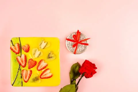 Appetizing cake covered with icing, decorated with hearts of strawberries and Stock Photos