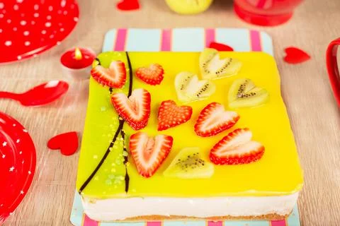 Appetizing cake covered with icing, decorated with hearts from pieces of stra Stock Photos