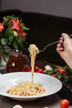 Appetizing carbonara paste with chicken improperly wound on fork. Spaghetti i Stock Photos