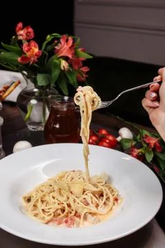 Appetizing carbonara paste with chicken improperly wound on fork. Spaghetti i Stock Photos