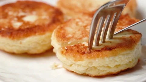 Appetizing cheese pancake is pierced with fork and cut with knife 库存影片 217406562