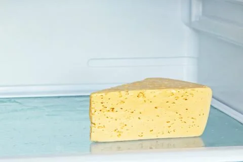 Appetizing cheese on refrigerator shelf. Stock Photos