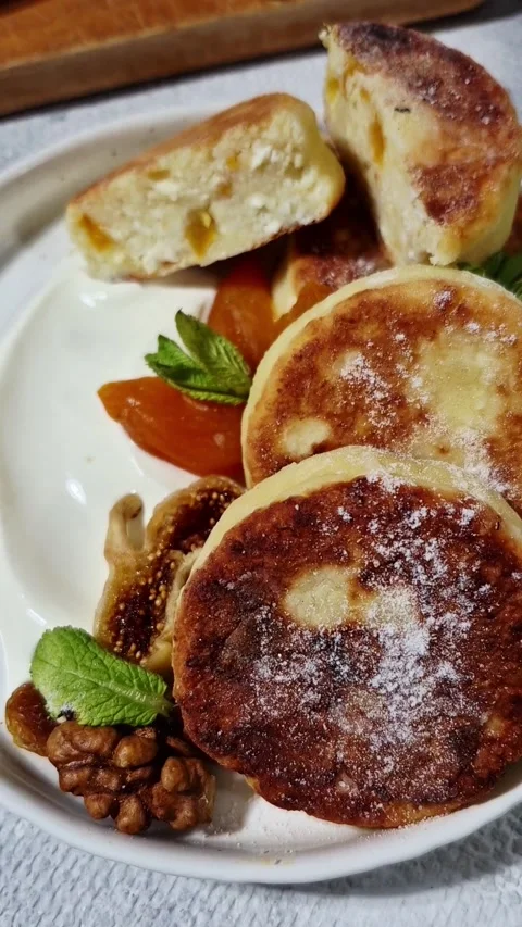 Appetizing cheesecakes with dried fruits on a white plate Video stock 325856624