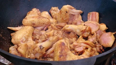 Appetizing chicken fried in a slow motion cauldron. Juicy chicken in a cauldron Stock Footage 280213785