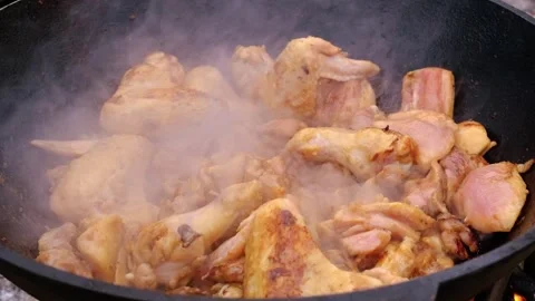 Appetizing chicken fried in a slow motion cauldron. Juicy chicken in a cauldron Stock Footage 280354862