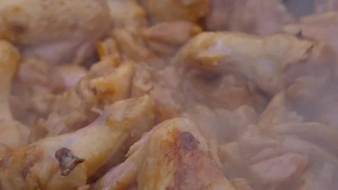 Appetizing chicken fried in a slow motion cauldron. Juicy chicken in a cauldron Stock Footage 284940663