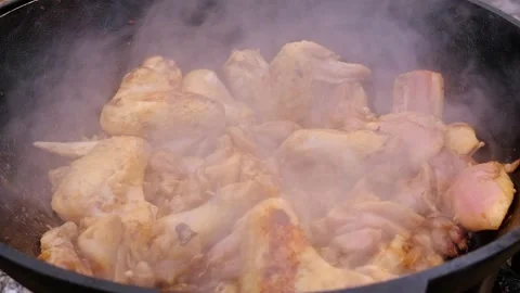 Appetizing chicken fried in a slow motion cauldron. Juicy chicken in a cauldron Stock Footage 284941021