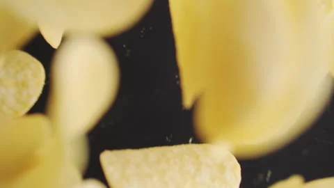 Appetizing chips fly in slow motion on a black background. Potato chips close up Stock Footage 255593413