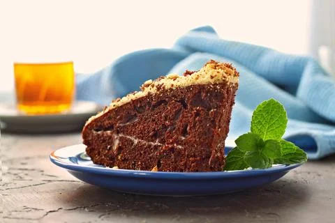 Appetizing chocolate cake with a sprig of mint and a glass of aromatic tea. 스톡 사진