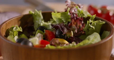 Appetizing Close-Up of Fresh Ingredients Falling into a Mediterranean Salad Stock Footage 294961577