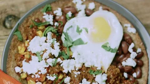 Appetizing cooking view of spoon lifting a bite of huevos rancheros Stock Photos