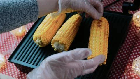 Appetizing culinary study: grilling whole corn until golden Foto stock