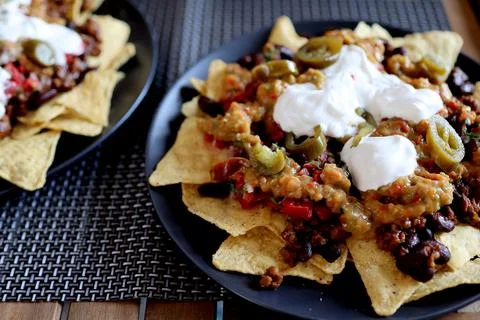 Appetizing dish on a plate: corn chips nachos with fried minced meat and Stock Photos