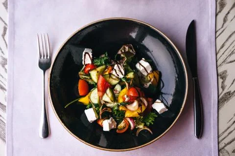 Appetizing dish in the restaurant, serving on the table with a lilac tablecloth. Stock Photos