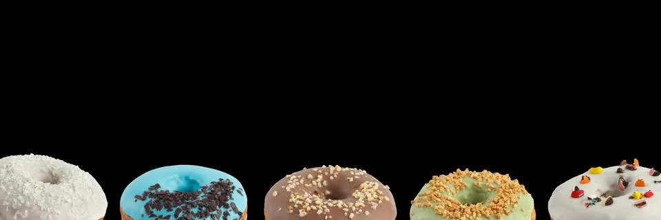 Appetizing donuts with multi-colored icing on a black background. Isolated. B Stock Photos
