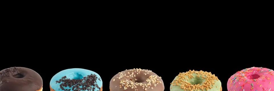 Appetizing donuts with multi-colored icing on a black background. Isolated. B Stock Photos