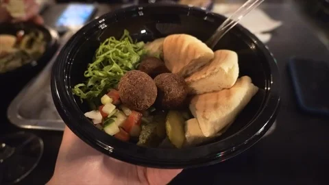 Appetizing falafel with pita bread and vegetable salad on plate in the hands of Stock Footage 121006214