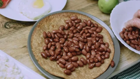 Appetizing food view of placing a heart-shaped fried egg over beans Stock Footage 342152933